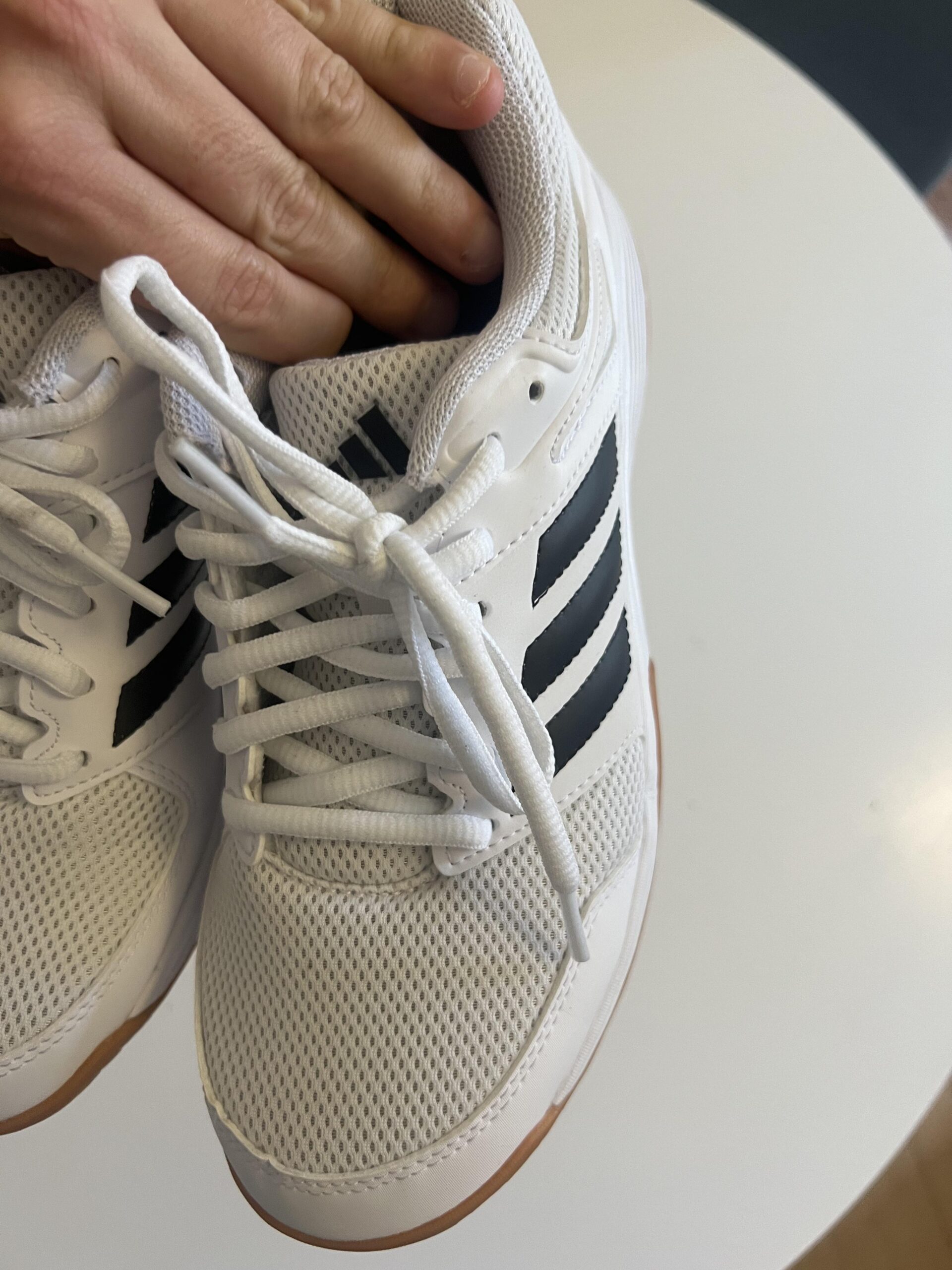 Close-up of the textile upper, laces and toe box on white adidas Speedcourt indoor court shoes