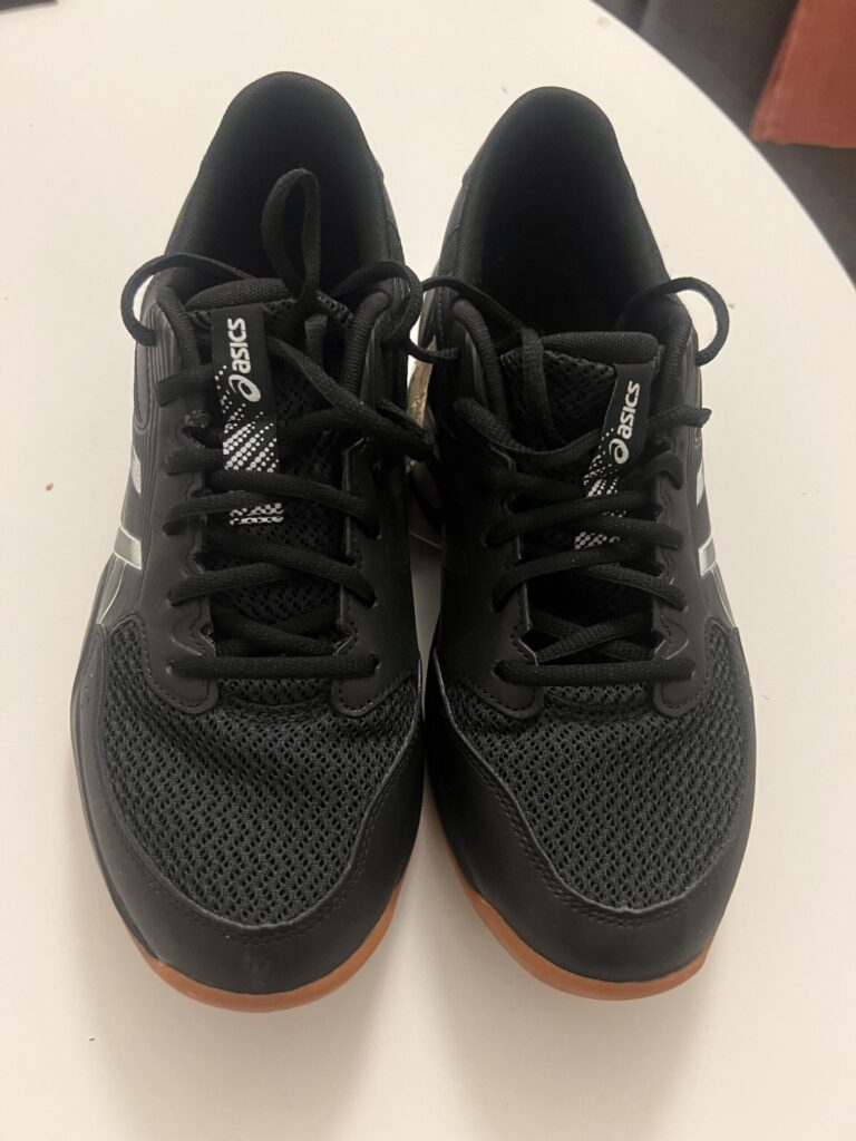 Black and gunmetal ASICS GEL-ROCKET 12 shoes, photographed together from above after eight hours of indoor pickleball