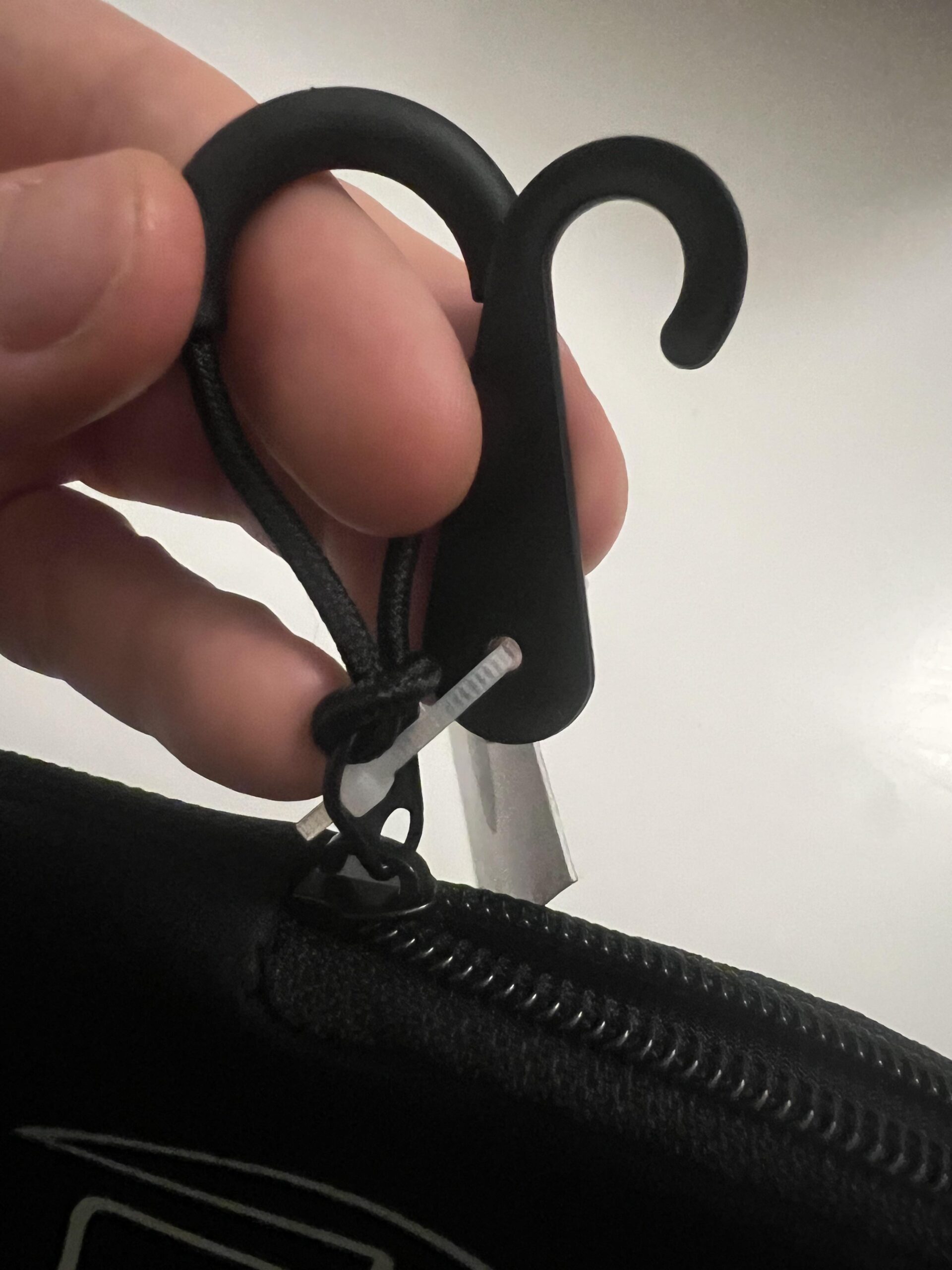 Close-up of GAMMA paddle cover's small hanging hook beside the zipper