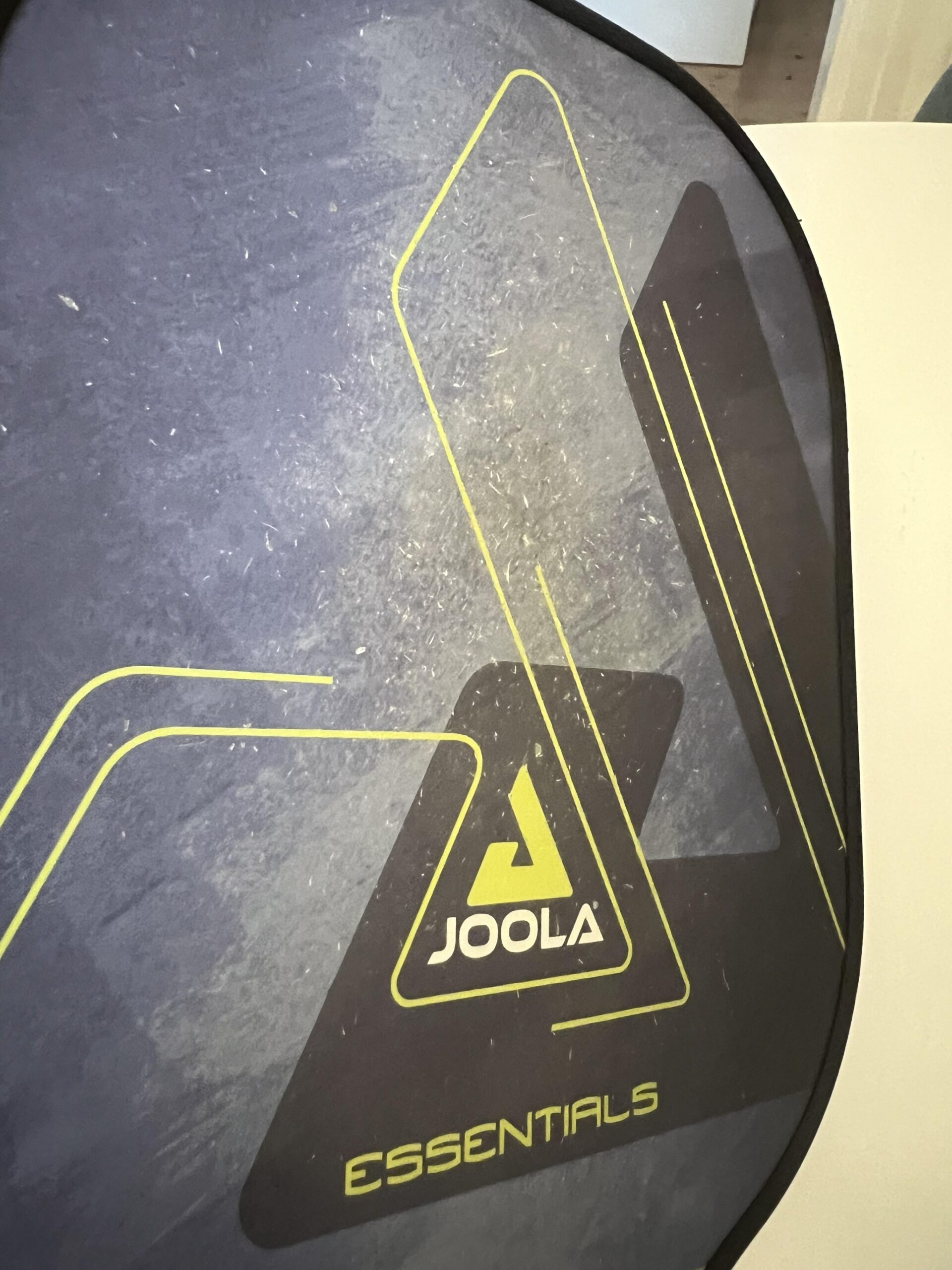 Desgaste visível na face de fibra de vidro da raquete JOOLA Essentials usada no clube