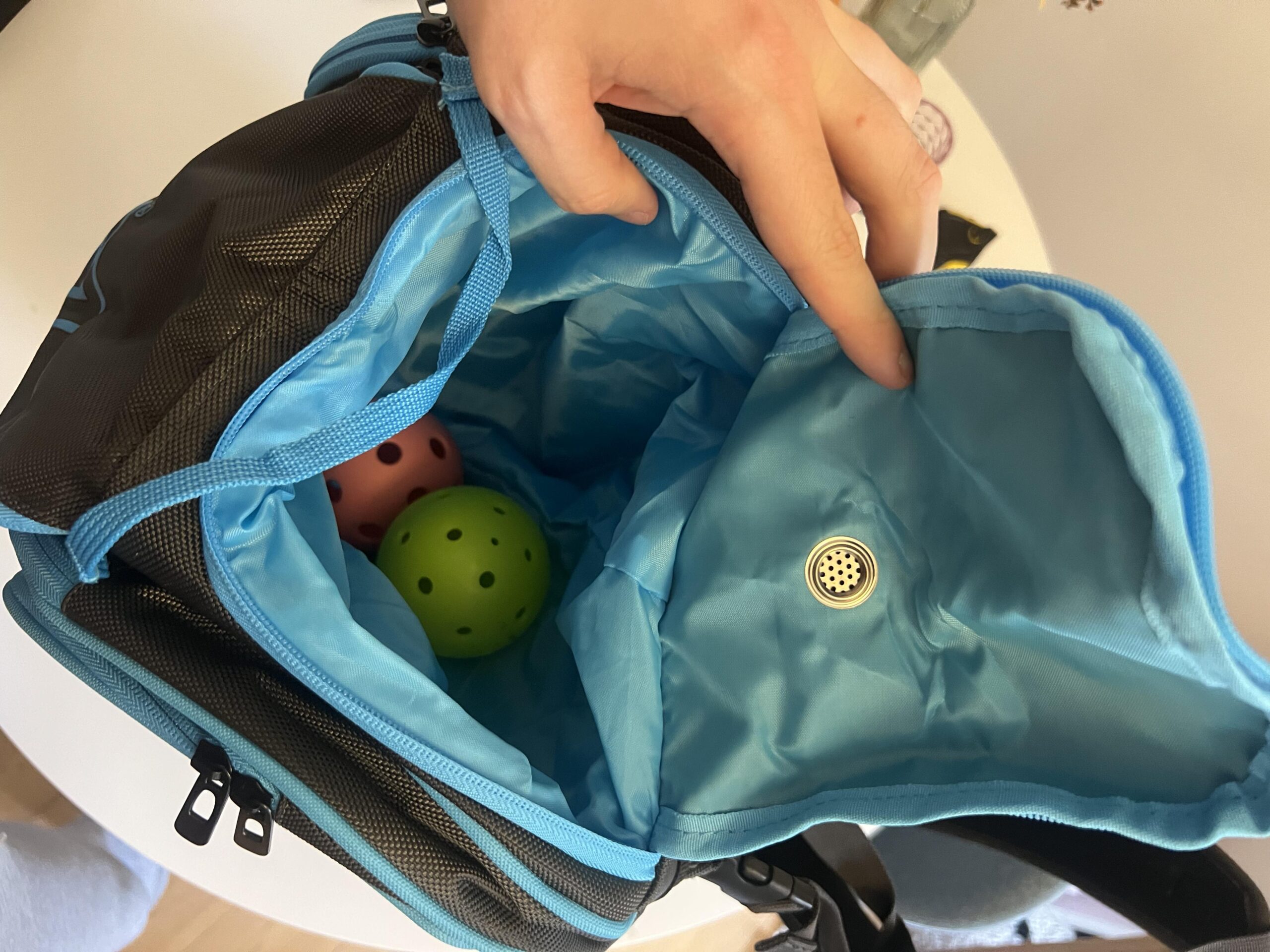 Opened light blue accessories pocket holding pickleballs in JOOLA Tour Elite bag