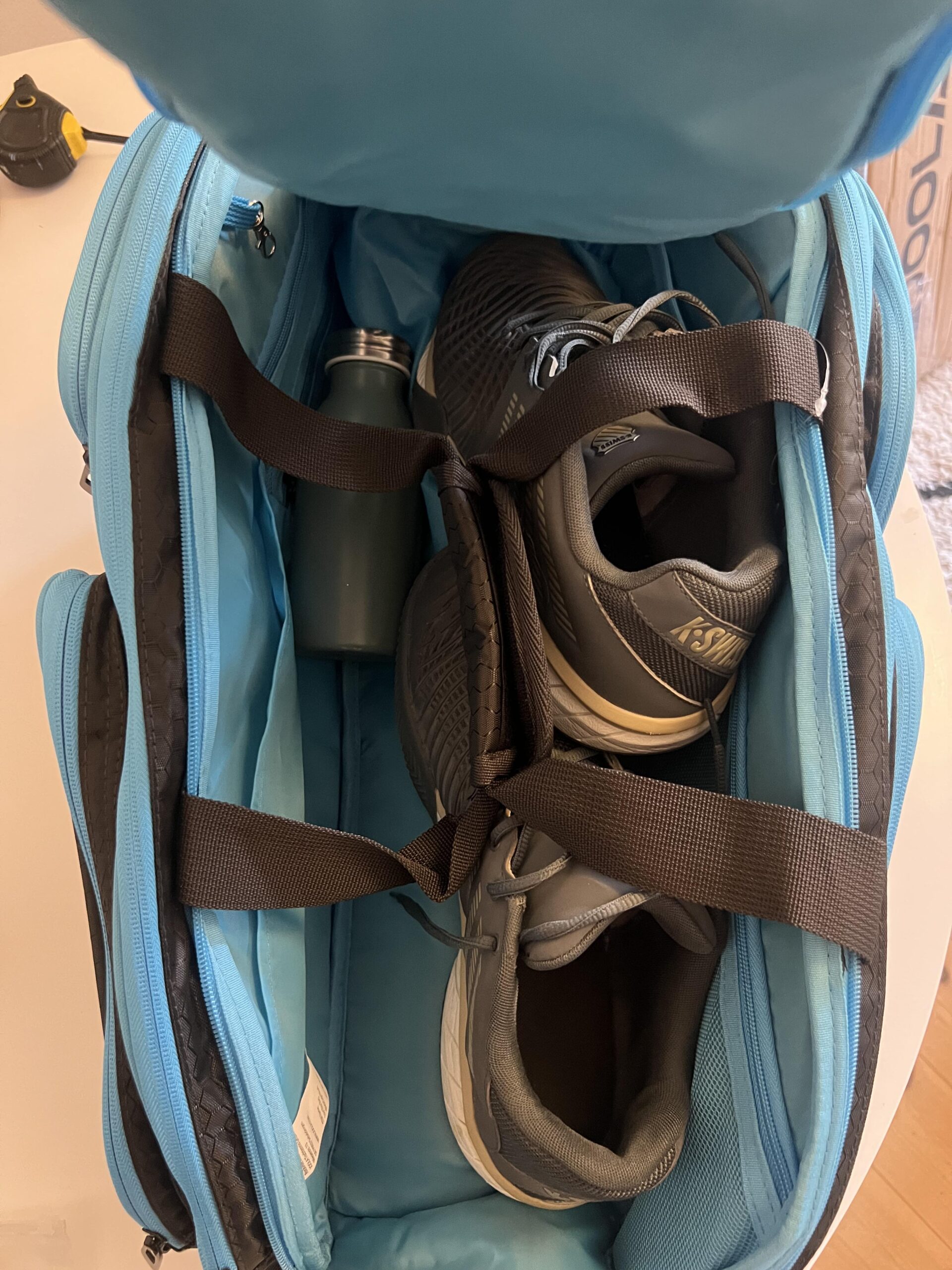 Two pairs of pickleball court shoes inside a JOOLA Tour Elite bag