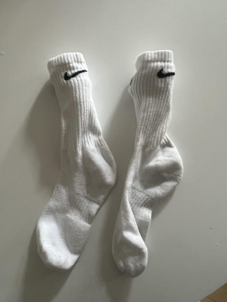 Original photo of two white Nike Everyday Cushioned crew socks with black Swoosh logos