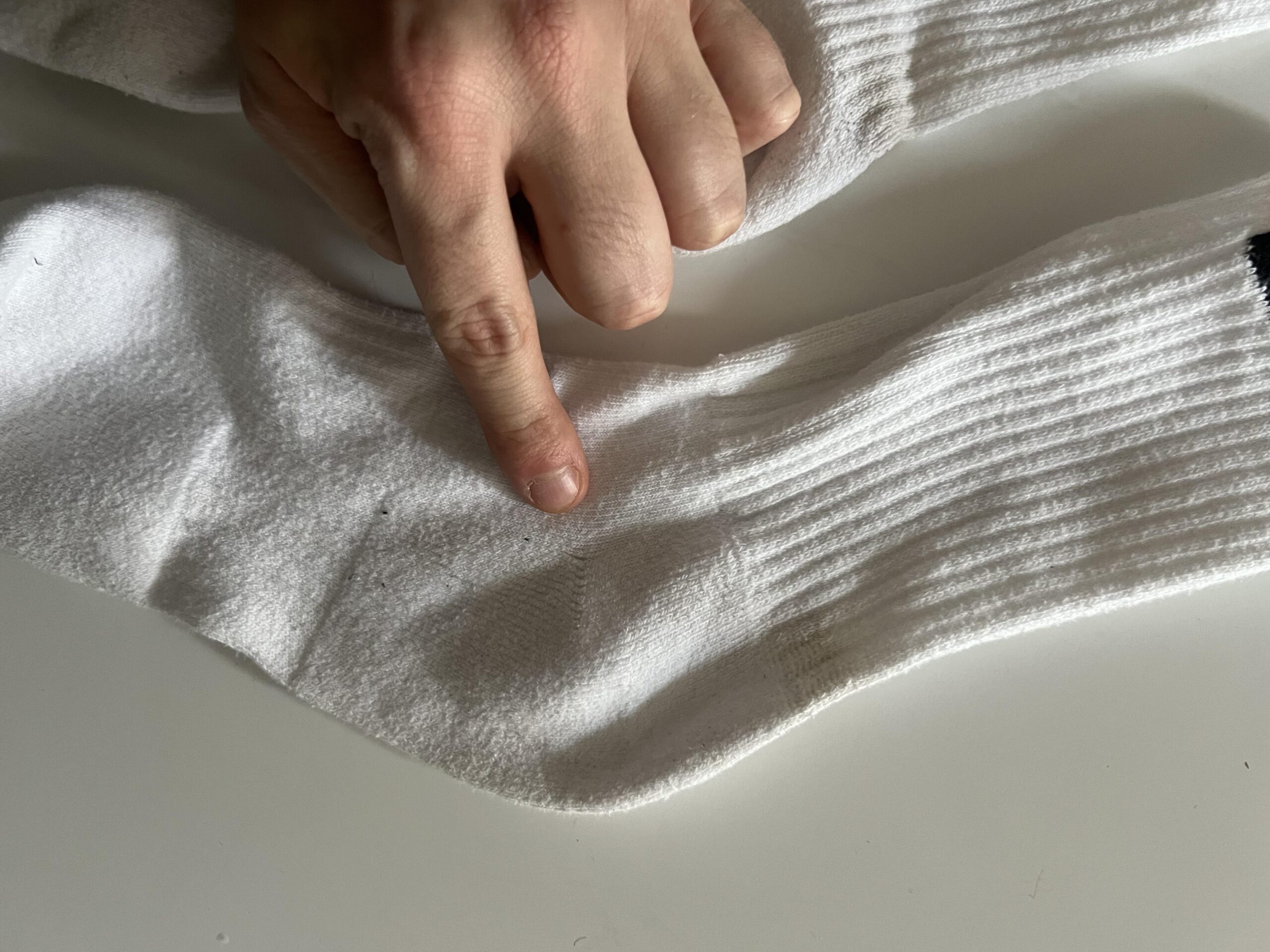 Close-up of ribbing and knit texture on a used white Nike Everyday Cushioned sock
