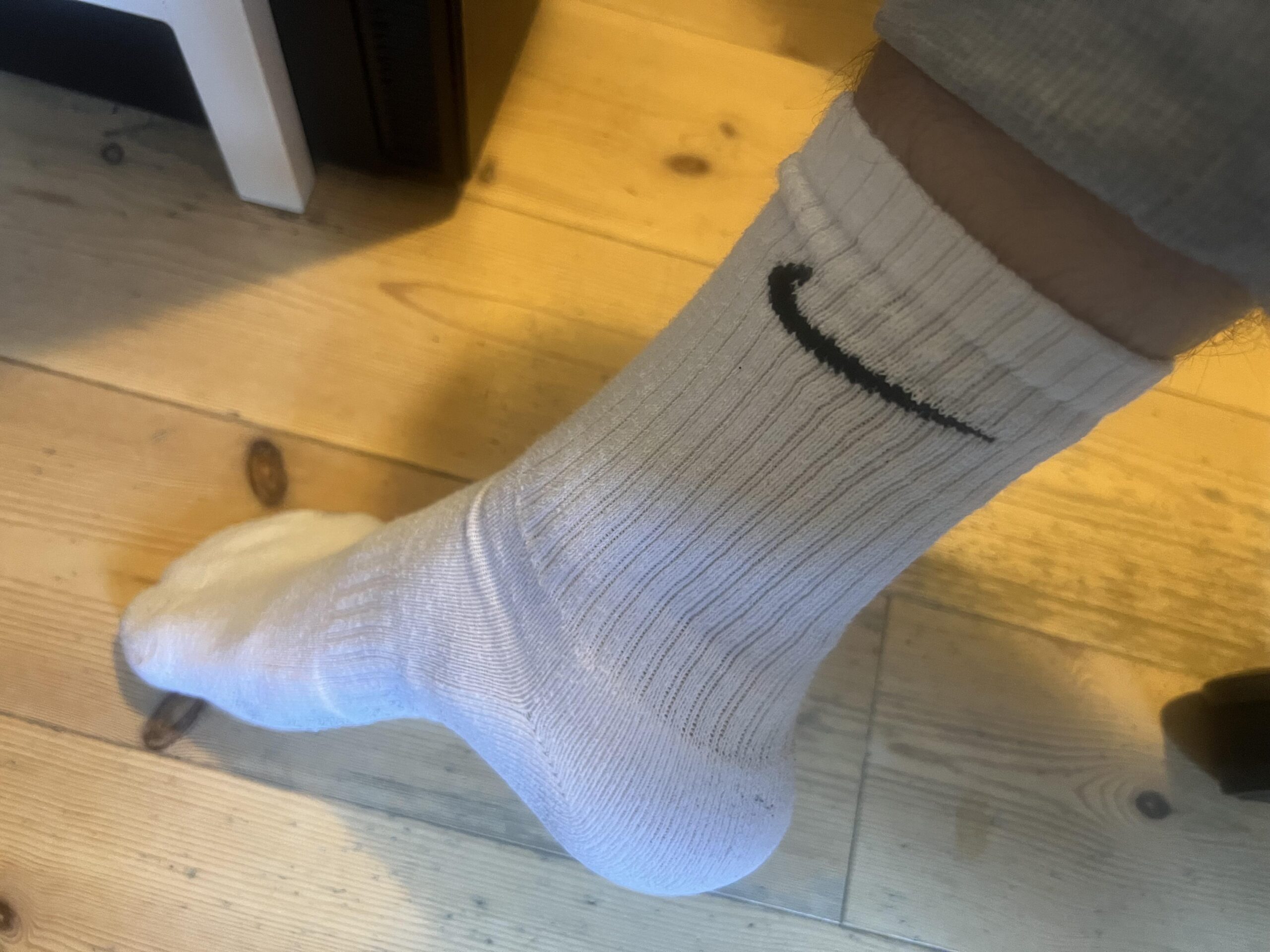 White Nike SX7664 crew sock worn on foot showing black Swoosh and crew height