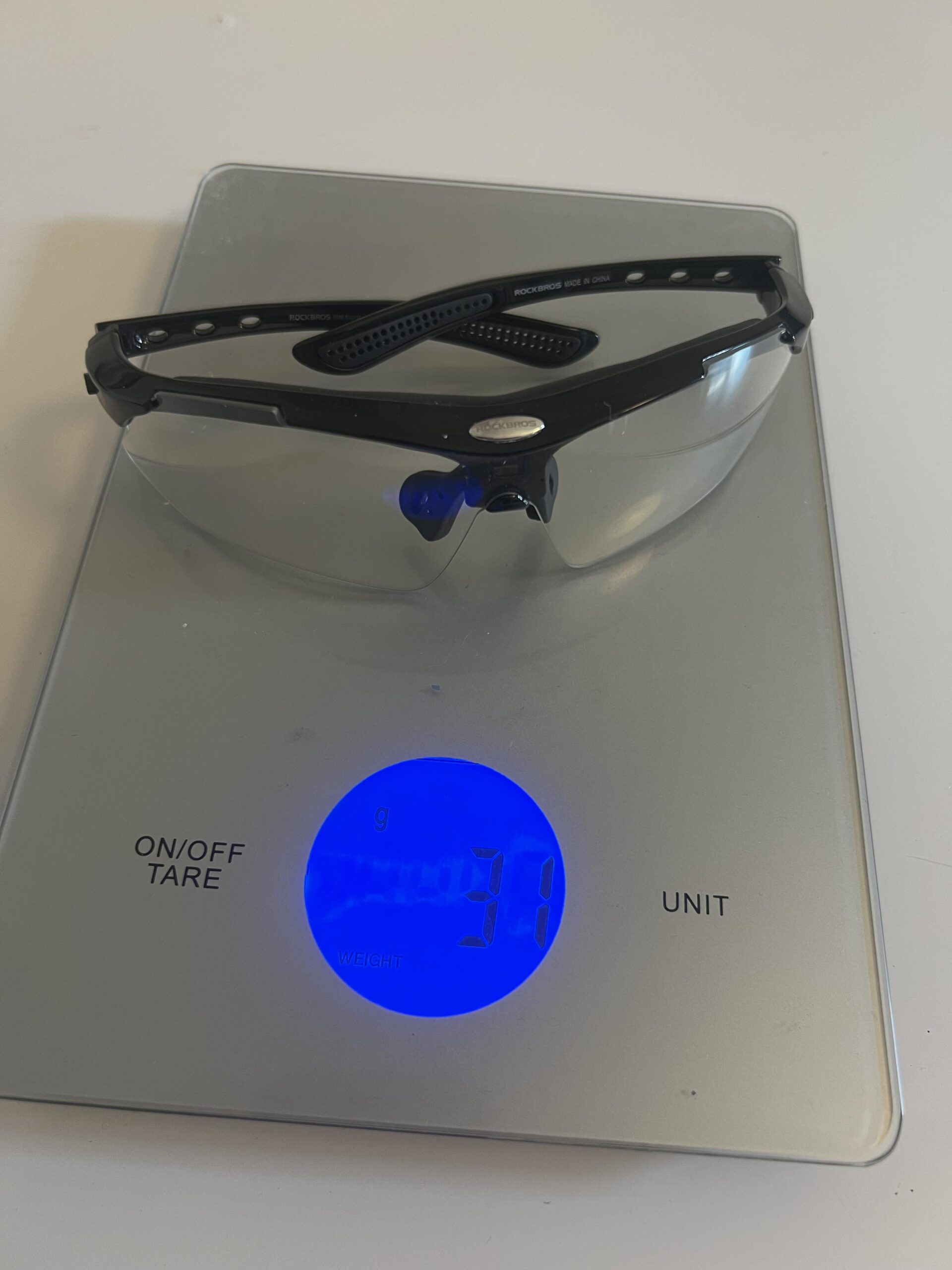 ROCKBROS photochromic pickleball glasses measured at 31 grams on a digital scale